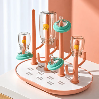egoutoire biberon rose sur table blanc.