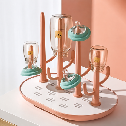 egoutoire biberon  rose sur  table blanc.