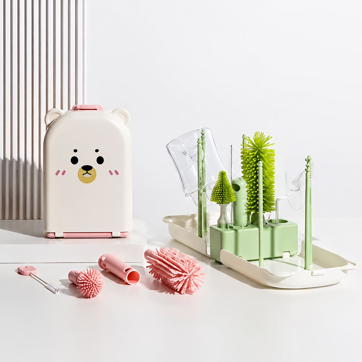 egouttoir biberon vert  et brrosses rose sur table.