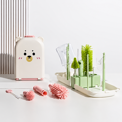 egouttoir biberon vert  et brrosses rose sur table.
