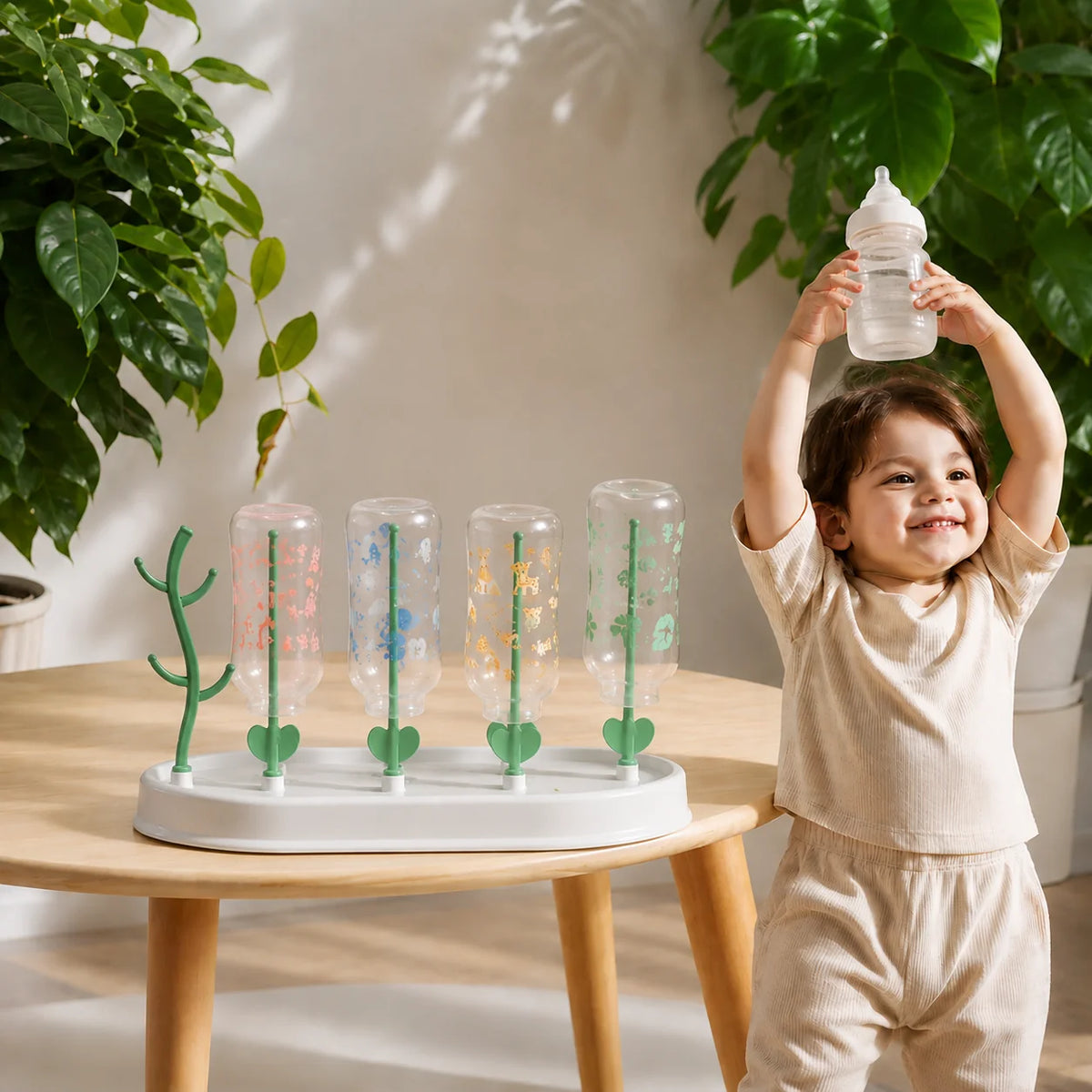 enfant joyeux presente biberon egouttoir biberon sur table.