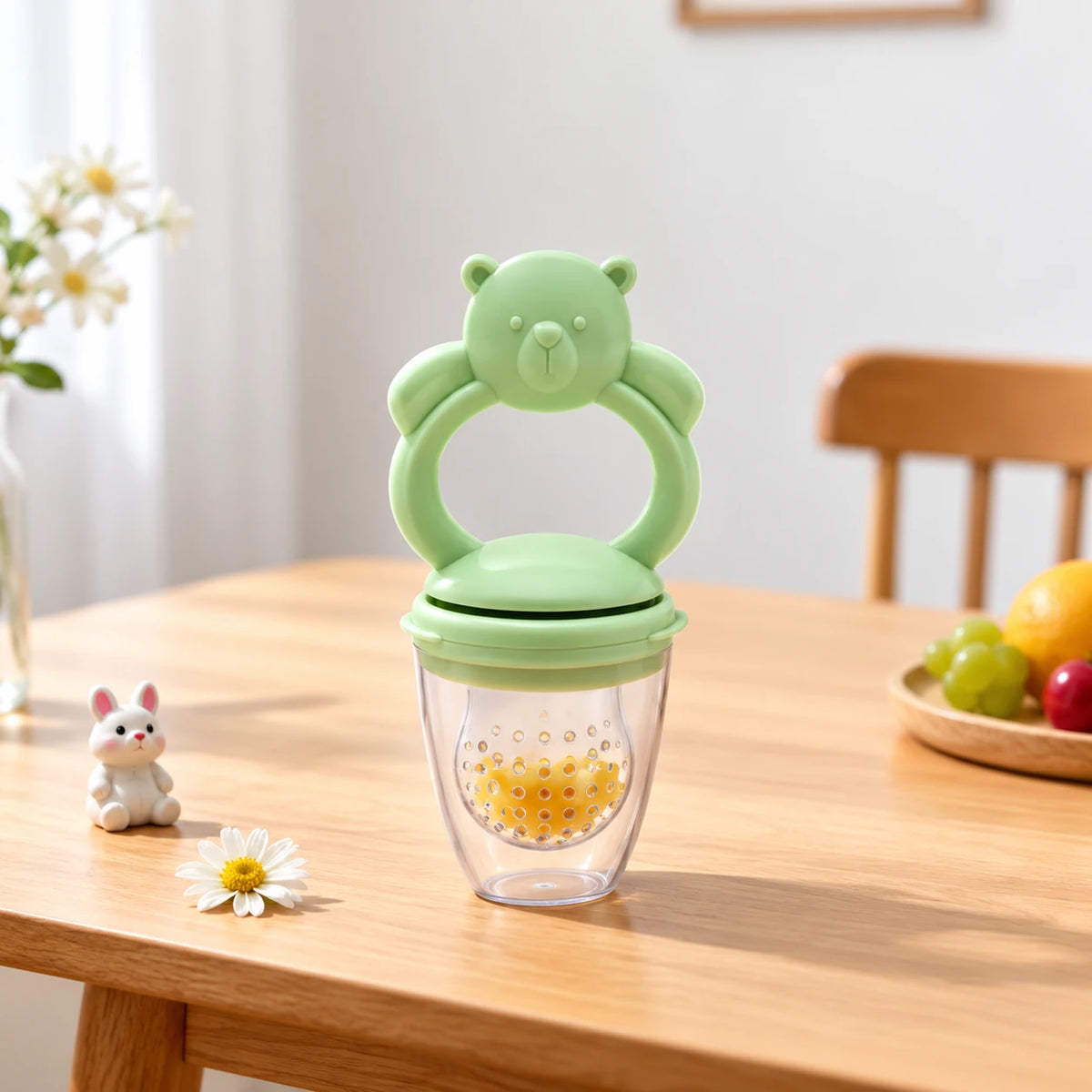 grignoteuse bebe vert sur table a  cote poupee