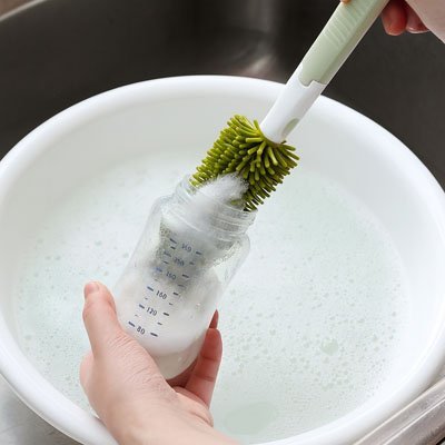 main lave biberon avec goupillon  biberon vert.