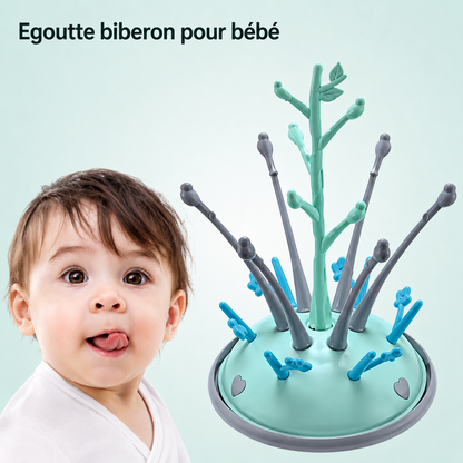 nourrisson regarde egoutte biberon sur table.